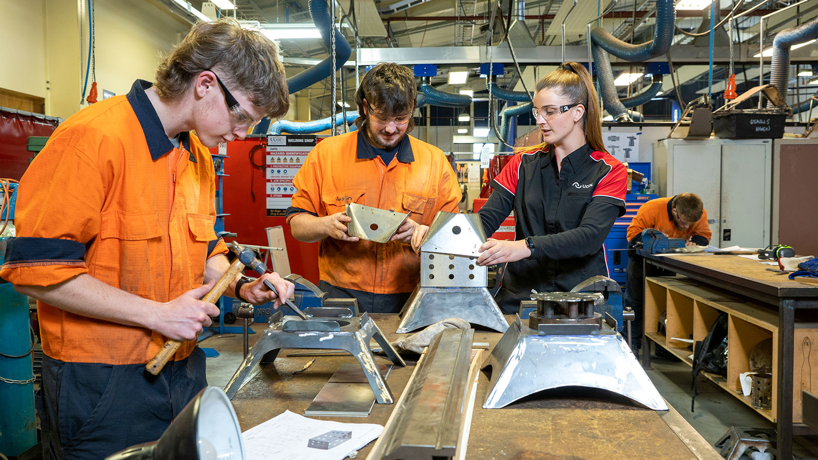 Two engineering students working with a lecturer